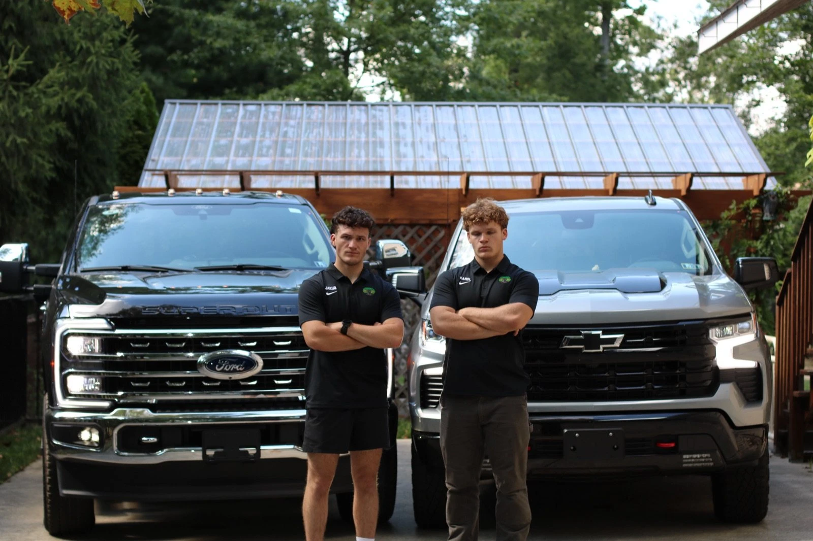 Jakub and Karol Miklus standing in front of their trucks